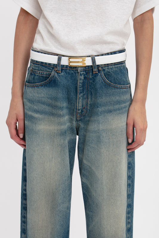 A person wearing blue jeans with a Victoria Beckham Exclusive Frame Belt In White Leather crafted from smooth calf leather.