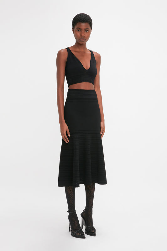 A woman in a Victoria Beckham Frame Detail Sleeveless Top In Black dress.