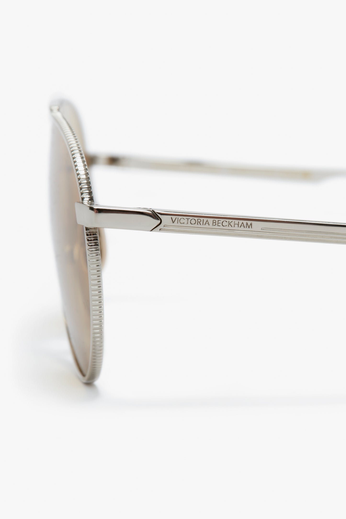 Close-up of the side of a Victoria Beckham branded V Metal Pilot sunglasses in Silver-Brown showing the intricate design on the temple.