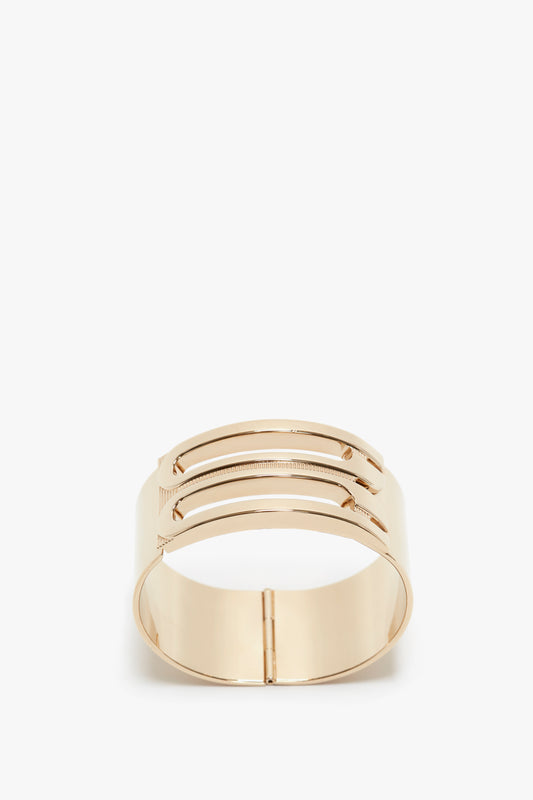 Exclusive Frame Bracelet In Gold by Victoria Beckham, with a sleek, modern design and detailed with two horizontal ridges, displayed on a white background.