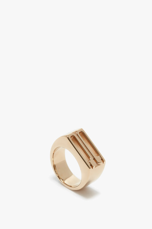 A polished rose gold-coated brass Exclusive Frame Signet Ring In Gold from Victoria Beckham with a wide band and minimalist design, displayed on a white background.