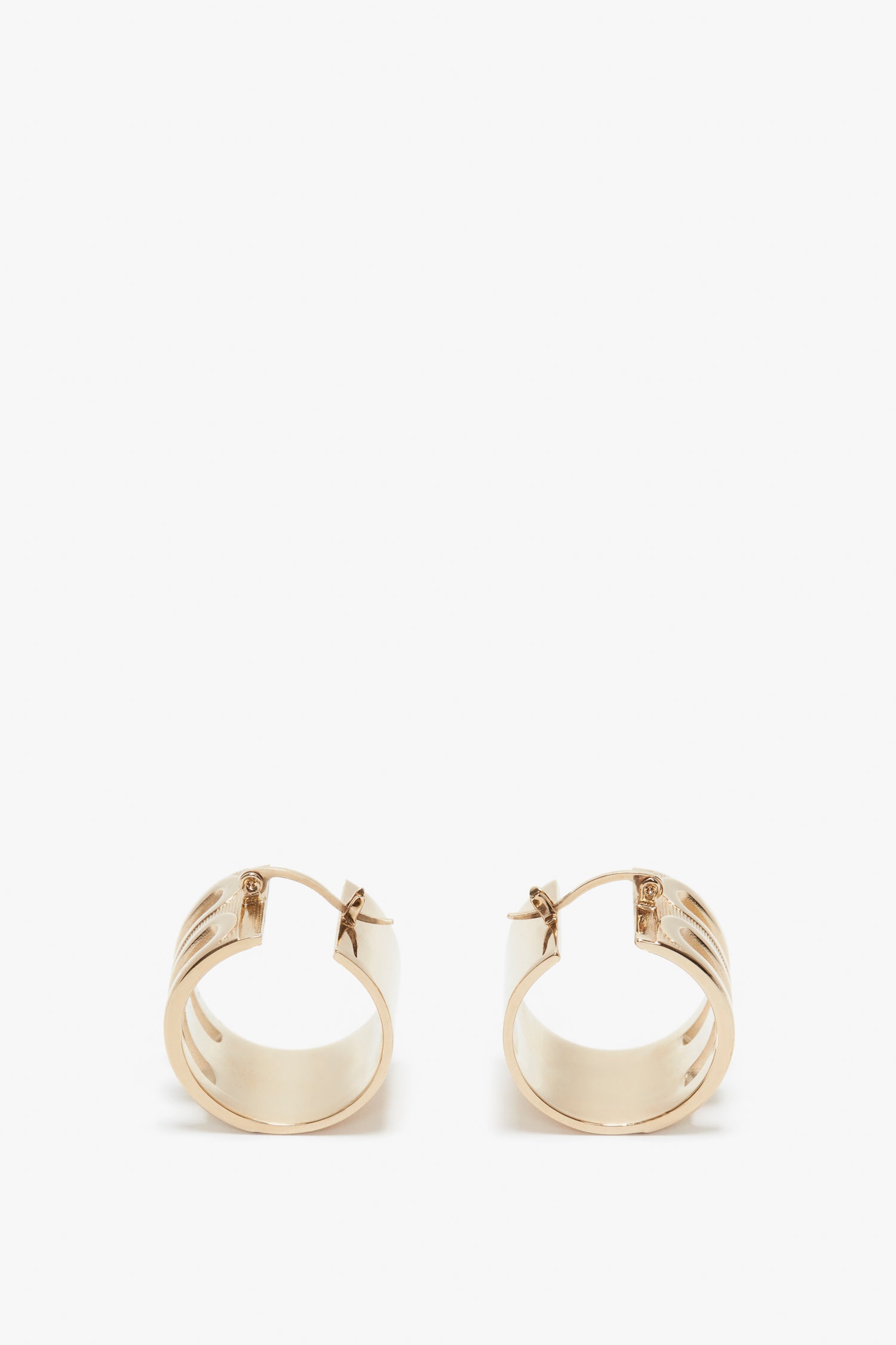 A pair of Exclusive Frame Hoop Earrings In Gold by Victoria Beckham with a latch back, isolated on a white background.