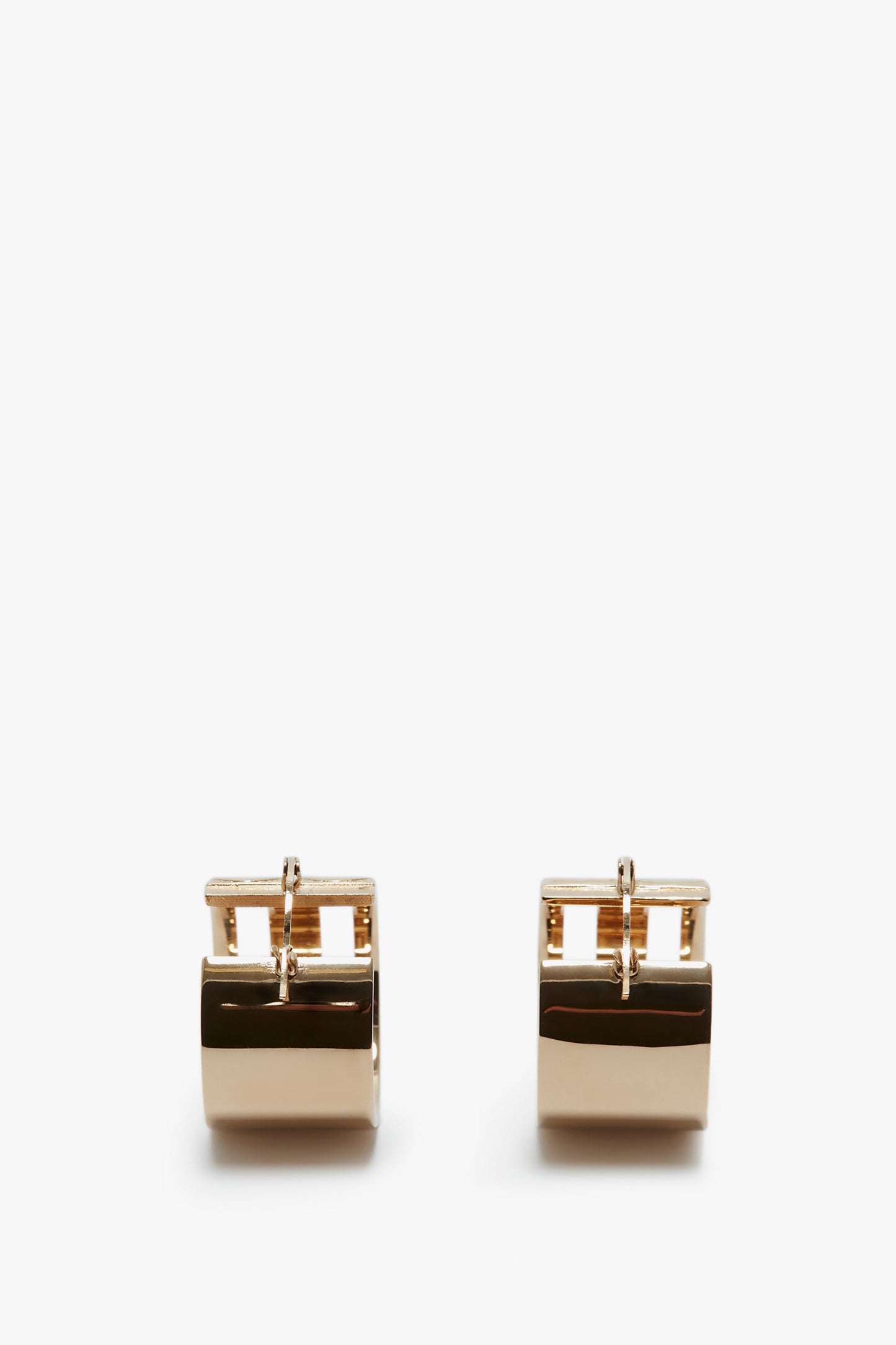 A pair of elegant, Victoria Beckham exclusive frame hoop earrings in gold on a white background.