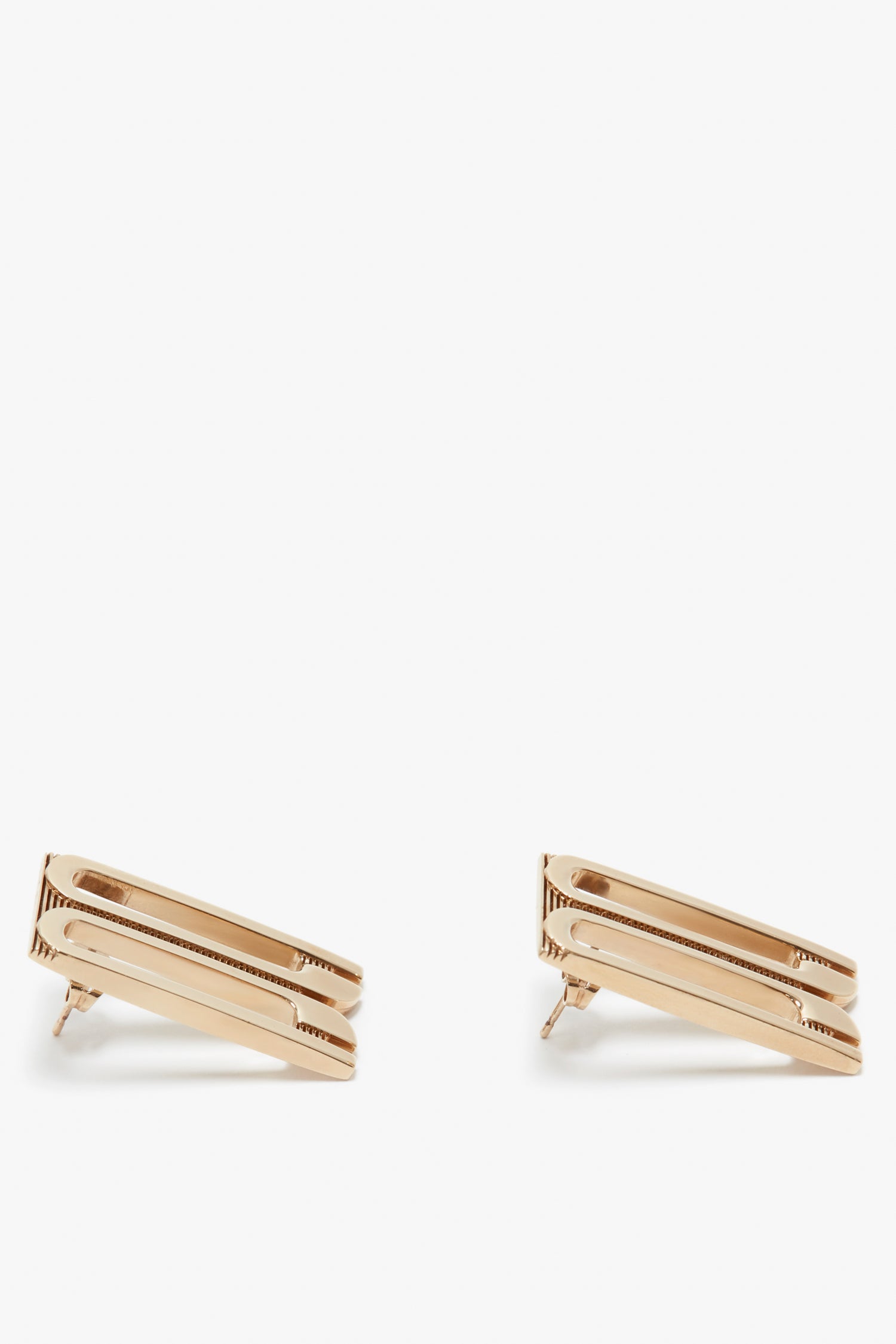 A pair of Exclusive Frame Stud Earrings In Gold by Victoria Beckham, with a minimalist design, isolated on a white background.