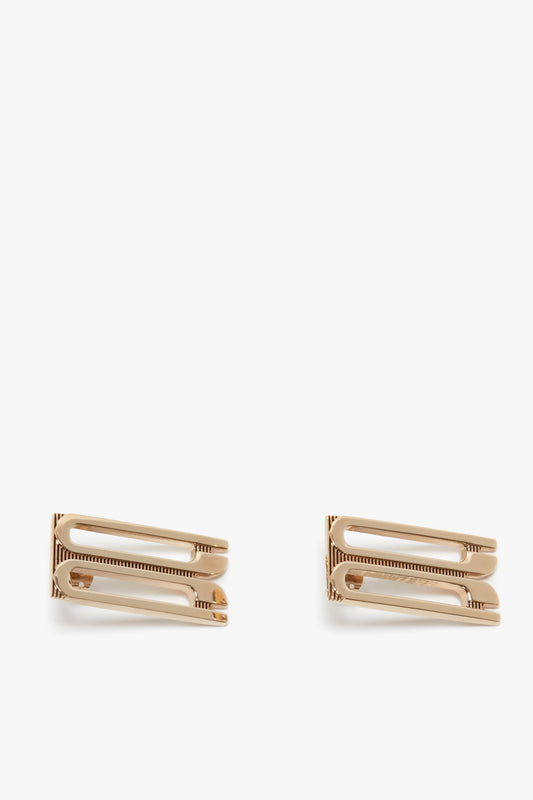 Two Exclusive Frame Stud Earrings In Gold with a sleek rectangular design, featuring small comb-like teeth, isolated on a white background by Victoria Beckham.