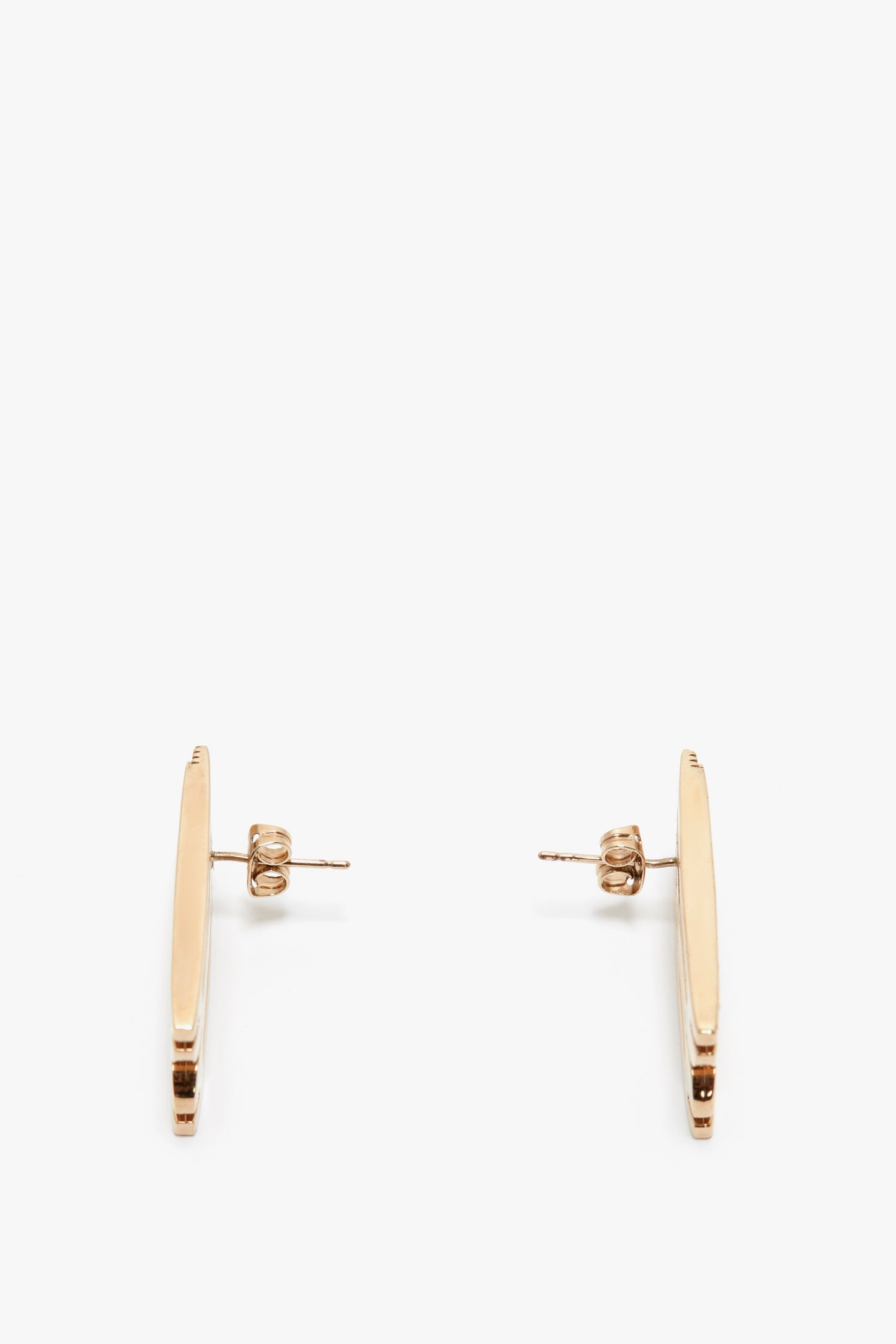 A pair of Victoria Beckham Exclusive Frame Stud Earrings in Gold plated brass bar earrings isolated on a white background.