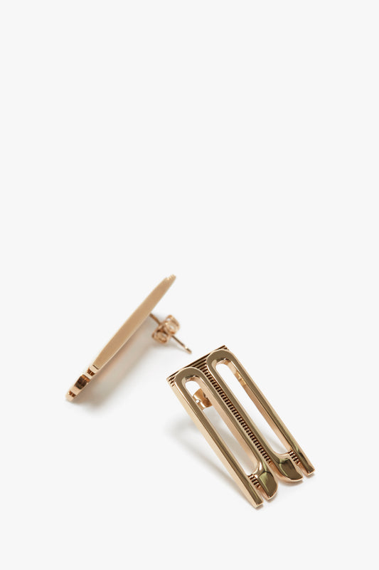 Victoria Beckham Exclusive Frame Stud Earrings In Gold with a streamlined, modern design on a white background.