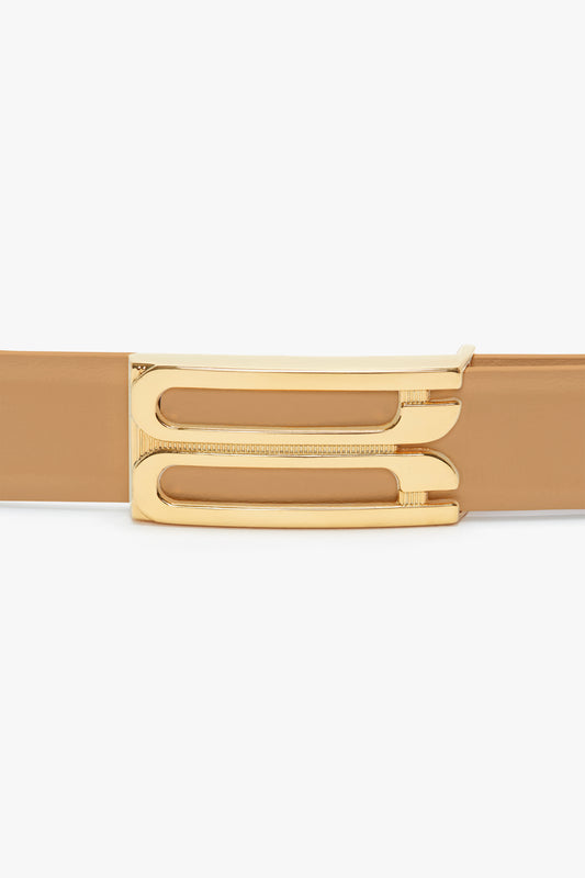 A close-up image of a Frame Belt in Camel Leather by Victoria Beckham with shiny gold hardware.