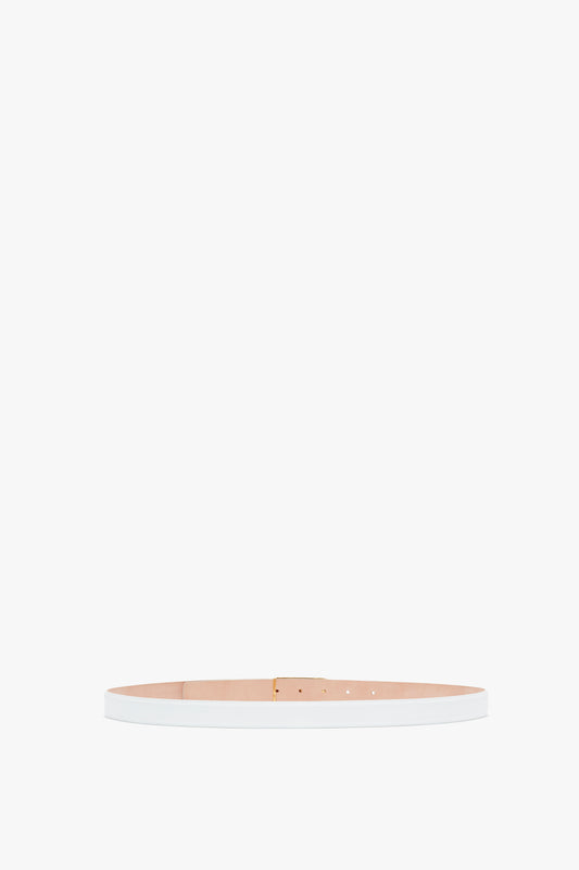 A slender, pale pink smooth calf leather Exclusive Frame belt with gold hardware, displayed straight on a white background by Victoria Beckham.