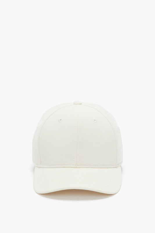 Front view of a plain beige Logo Cap In Antique White by Victoria Beckham against a white background.