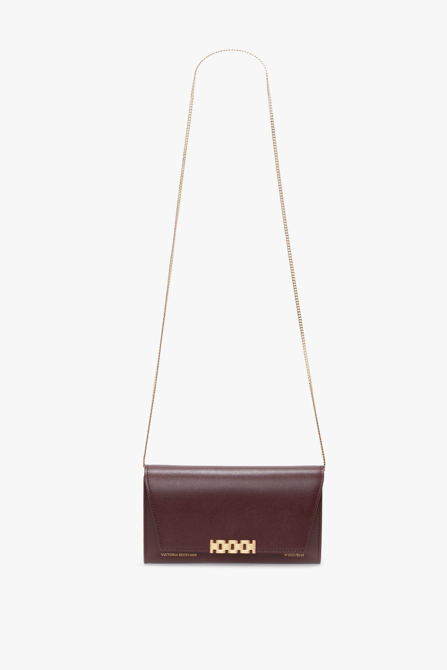 A Victoria Beckham Wallet On Chain In Burgundy Leather with a gold chain strap and a gold clasp closure on a white background.