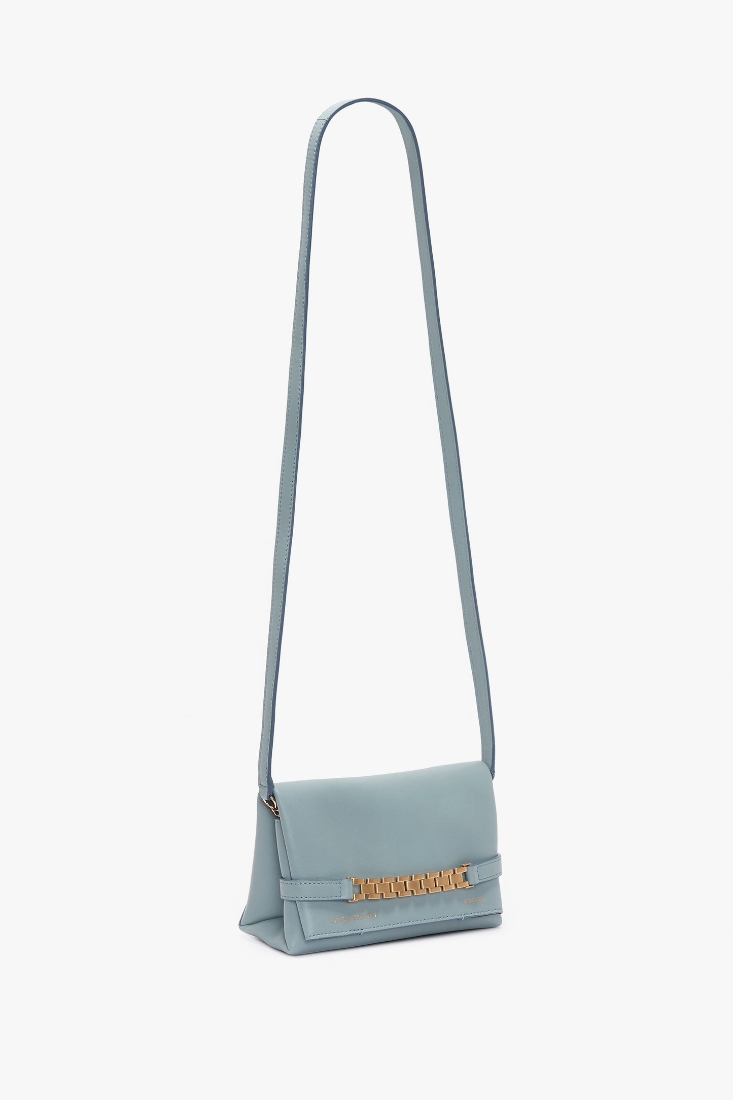 A Mini Chain Pouch Bag With Long Strap In Ice Leather by Victoria Beckham with a long strap and gold-tone chain detailing on the front flap, set against a white background.