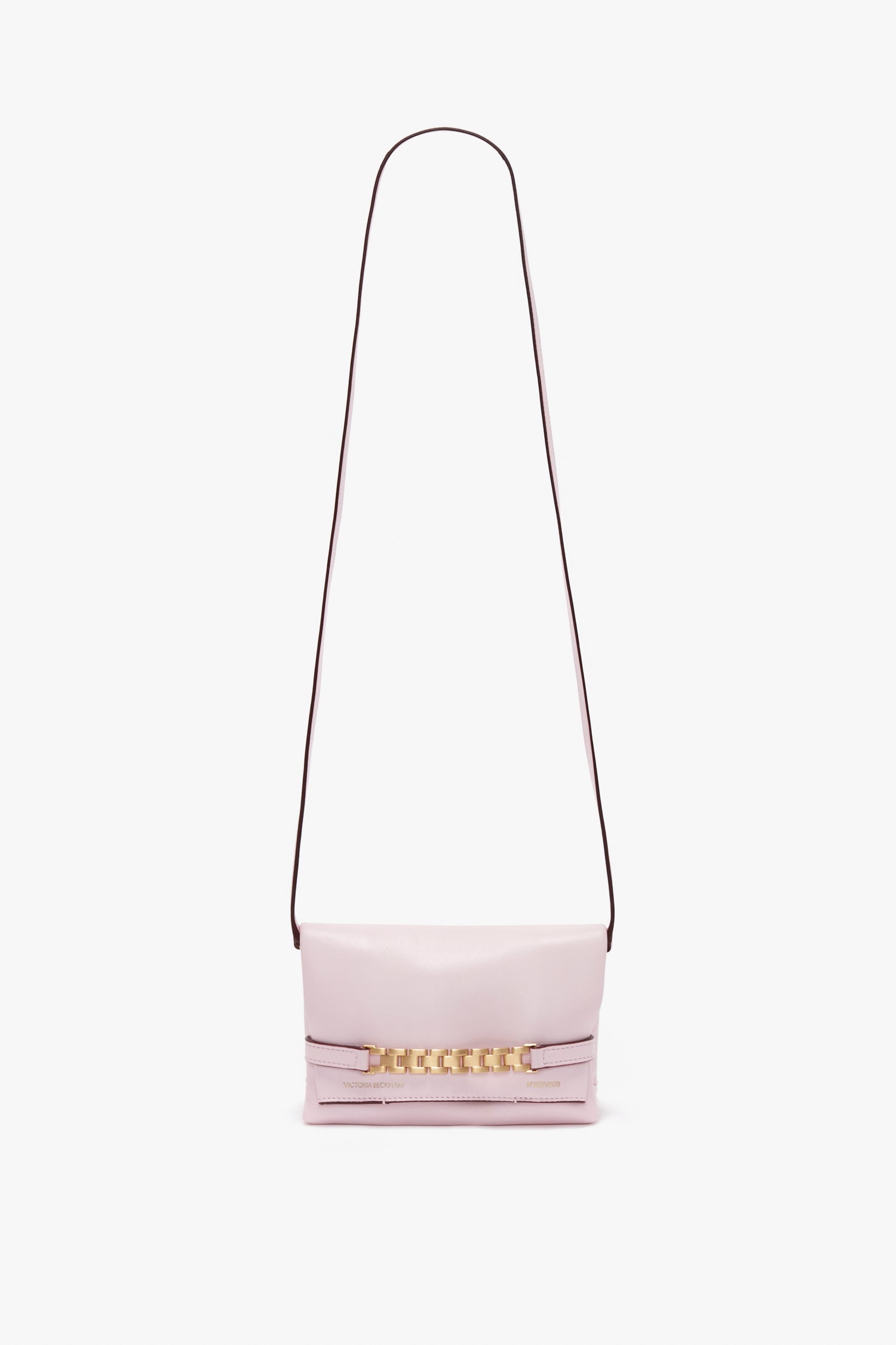 A light pink Mini Chain Pouch Bag With Long Strap In Orchid Leather by Victoria Beckham with a thin dark strap and gold chain detail on the front.
