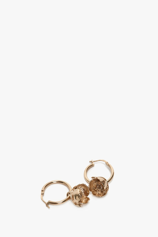 Exclusive Camellia Flower Hoop Earrings In Gold plated brass with textured, coin-like charms, isolated on a white background by Victoria Beckham.
