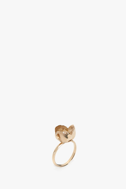Exclusive Camellia Flower Ring In Gold plated brass with a leaf-shaped setting on a plain white background by Victoria Beckham.