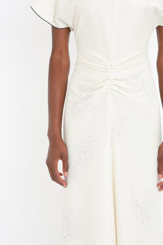 Close-up of a woman's torso in an elegant Victoria Beckham Gathered Waist Midi Dress In Cream with lace details, focusing on the texture and design of the fabric.