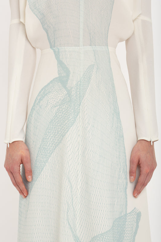A close up of a Victoria Beckham Long Sleeve Dolman Midi Dress In White-Blue Contorted Net featuring graphic twisted net print.