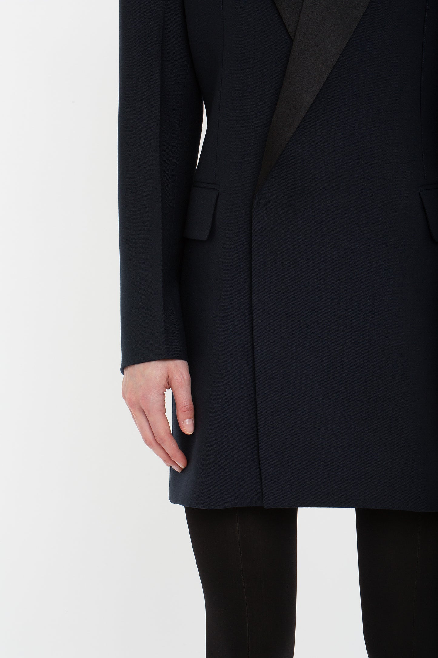 A person is shown from the shoulders down wearing an Exclusive Fold Shoulder Detail Dress In Midnight by Victoria Beckham. The person's left arm is relaxed by their side.