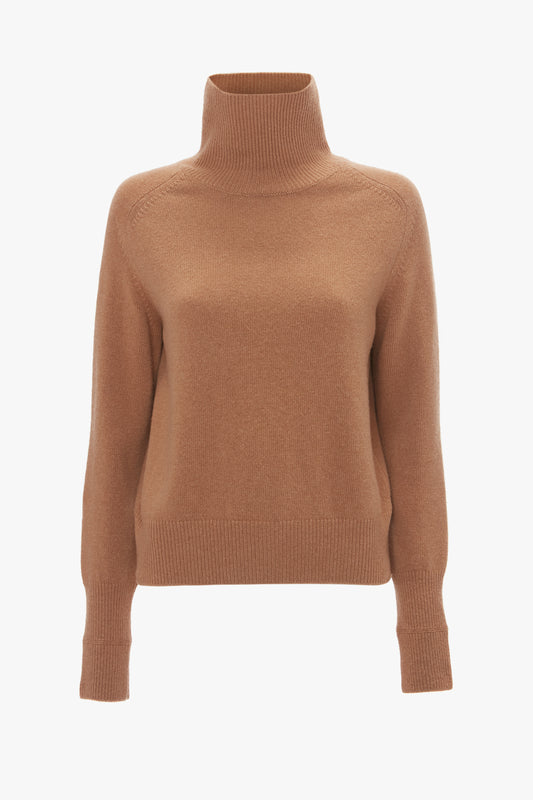A tobacco-colored lambswool polo neck jumper with long sleeves and ribbed cuffs, isolated on a white background. Brand Name: Victoria Beckham