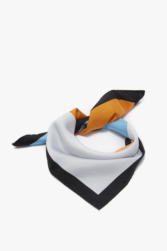 A Victoria Beckham printed silk twill scarf with bold stripes in black, white, blue, and orange, arranged artistically on a white background.