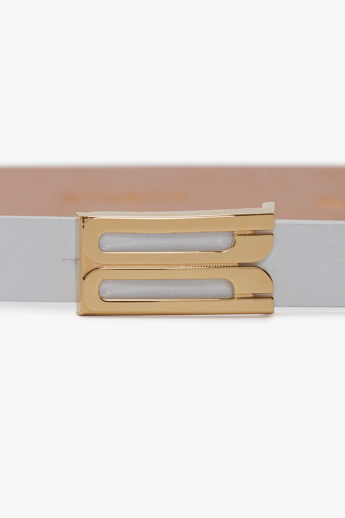 A close-up view of a Victoria Beckham Exclusive Micro Frame Belt In White Leather with a polished gold buckle.