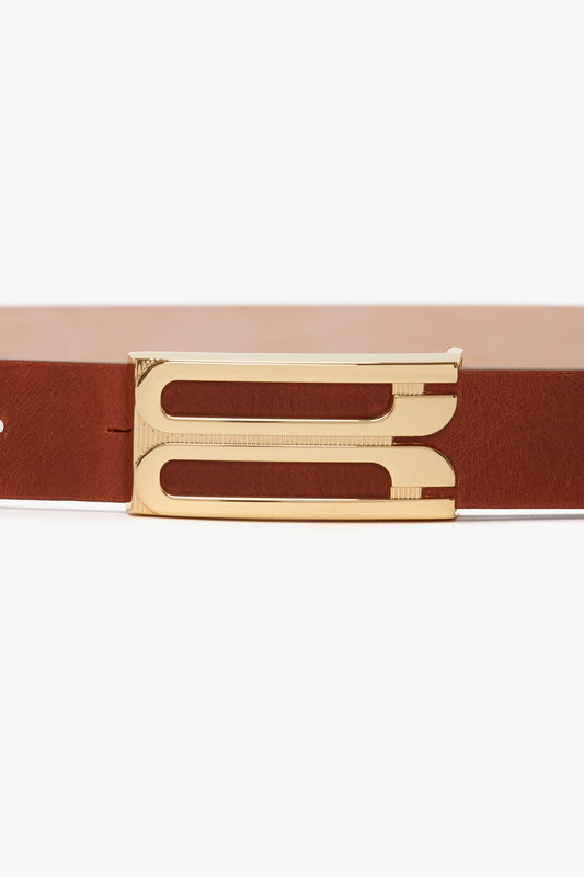Calf leather belt with a polished gold-tone buckle, isolated on a white background. 
Product Name: Exclusive Frame Buckle Belt In Tan Leather
Brand Name: Victoria Beckham