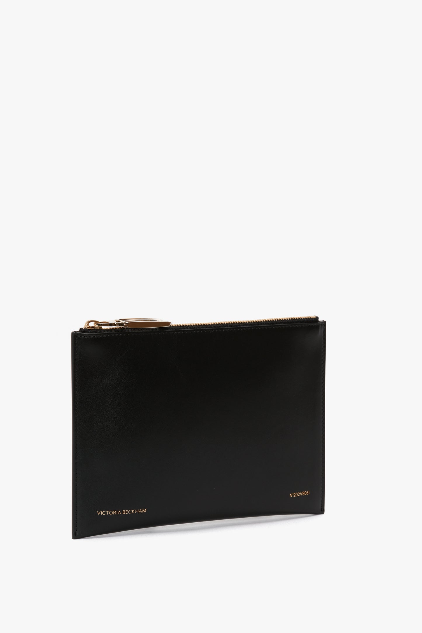 Victoria Beckham's B Frame Pochette Bag In Black Leather is crafted from smooth calf leather, featuring gold lettering and a gold zipper pull. Its compact design is perfect for carrying everyday essentials.