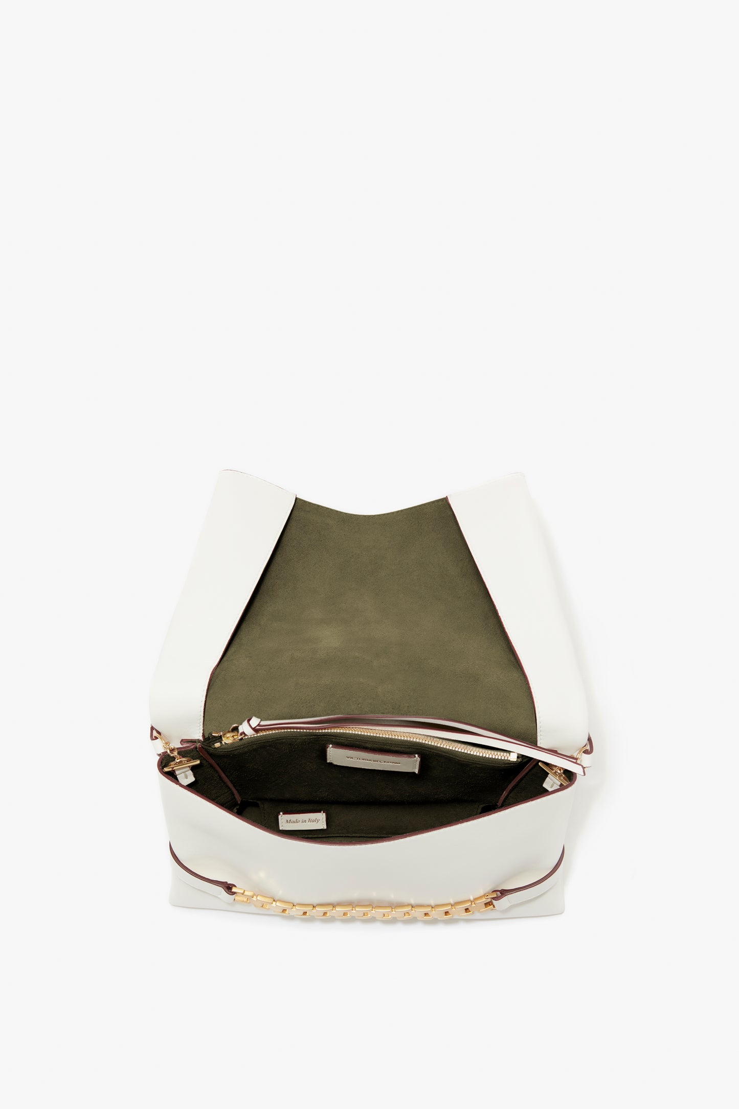 An open Victoria Beckham Chain Pouch with Strap in white leather, showing a green interior and a zippered compartment.