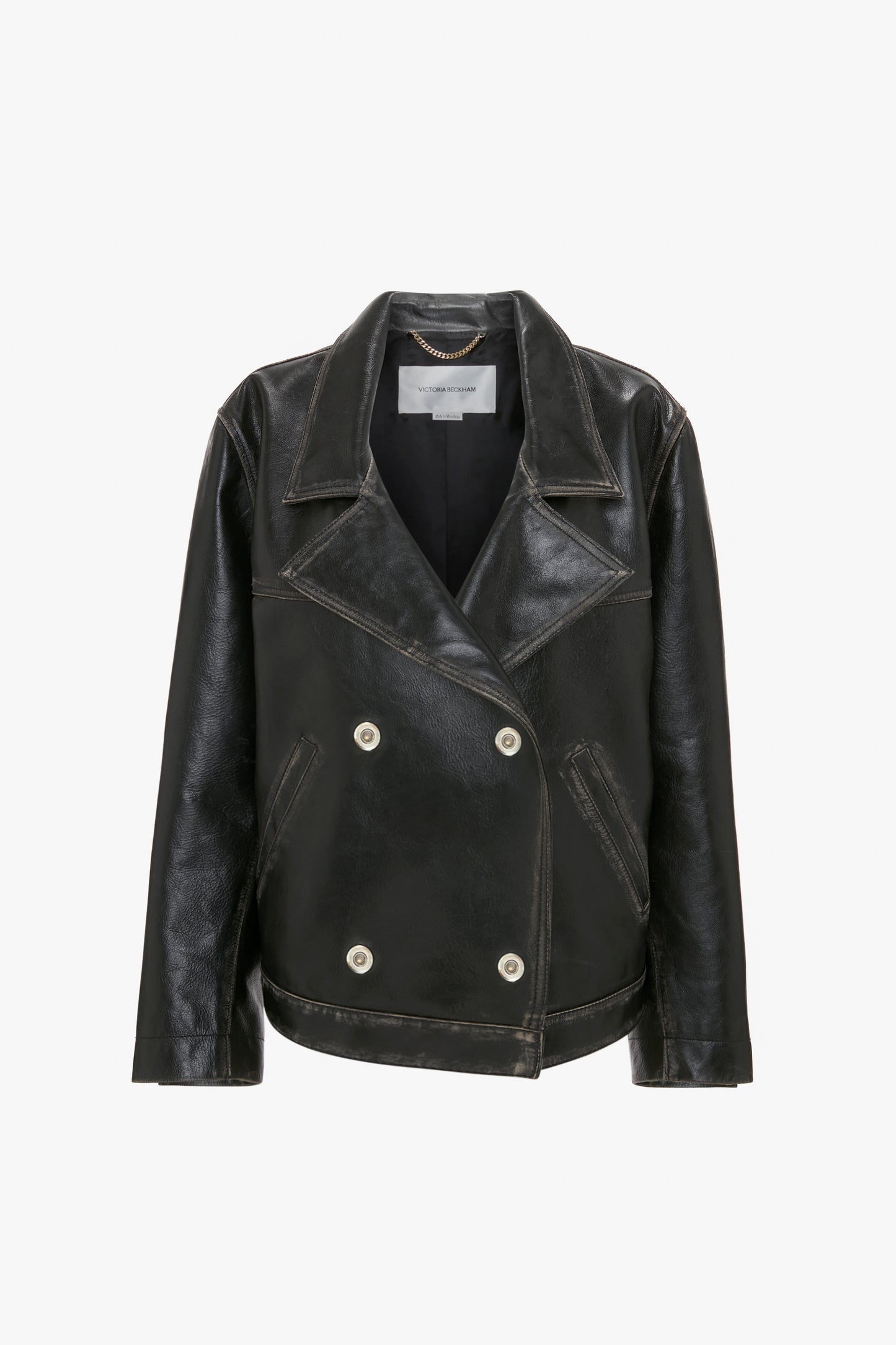 An Oversized Leather Jacket In Black by Victoria Beckham with a wide collar and white buttons, featuring an oversized biker-style design.
