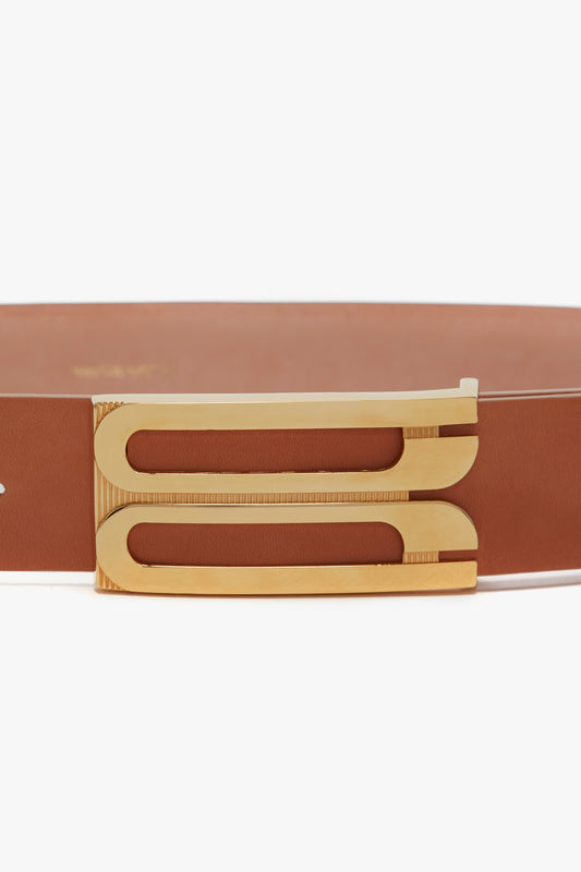 A close-up of the Victoria Beckham Exclusive Jumbo Frame Belt in Nude Leather featuring a gold buckle with a unique, geometric cut-out design.