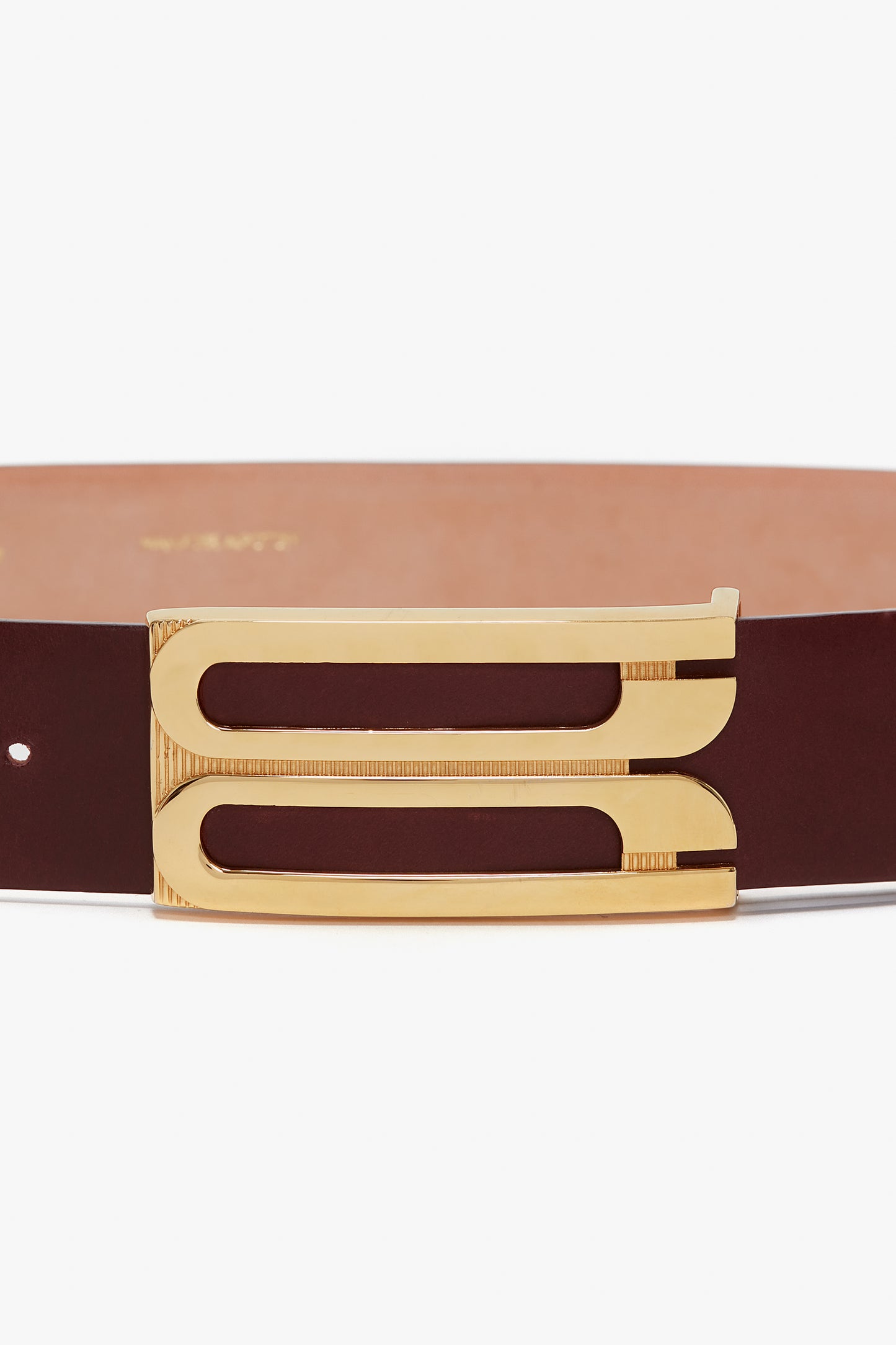 A Jumbo Frame Belt In Burgundy Leather from Victoria Beckham with distinctive gold hardware featuring two parallel rectangular slots.