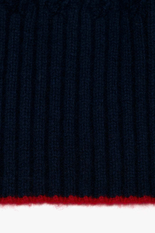 Close-up of a Victoria Beckham Exclusive Logo Patch Scarf In Navy with a thin horizontal red stripe at the bottom edge.