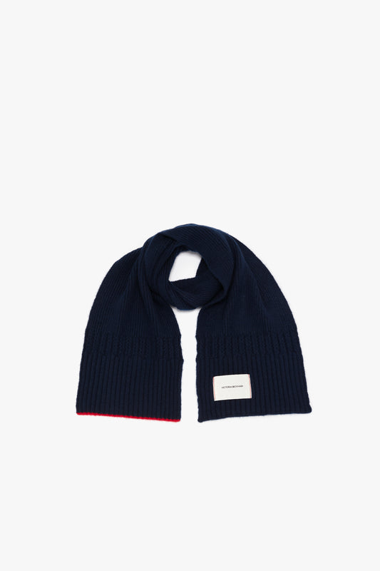 Navy blue ribbed scarf with a red trim and a white Exclusive Logo Patch Scarf in Navy label, displayed on a white background by Victoria Beckham.
