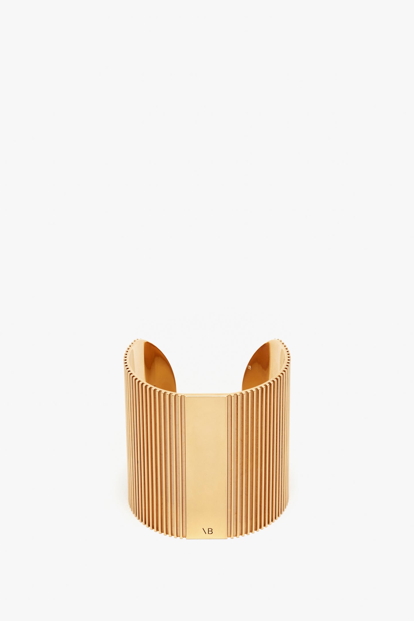 Victoria Beckham's Exclusive Perfume Cuff In Gold cuff bracelet with vertical ridges on a white background.