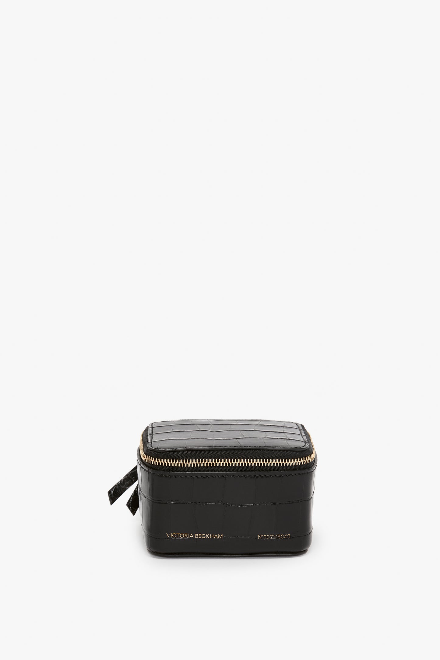 A black rectangular zippered jewellery box with a Victoria Beckham label, embossed croc leather, isolated on a white background.