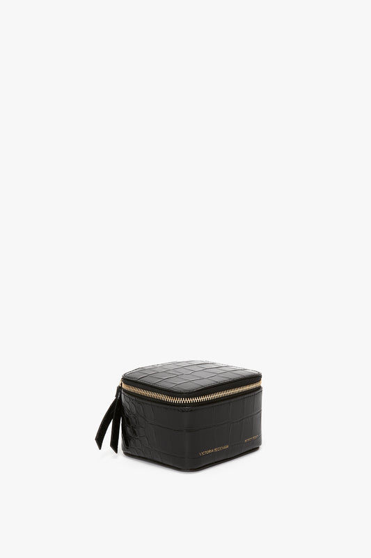 A Victoria Beckham Jewellery Box In Black Croc-Effect Leather with a gold-tone zip closure, isolated on a white background.