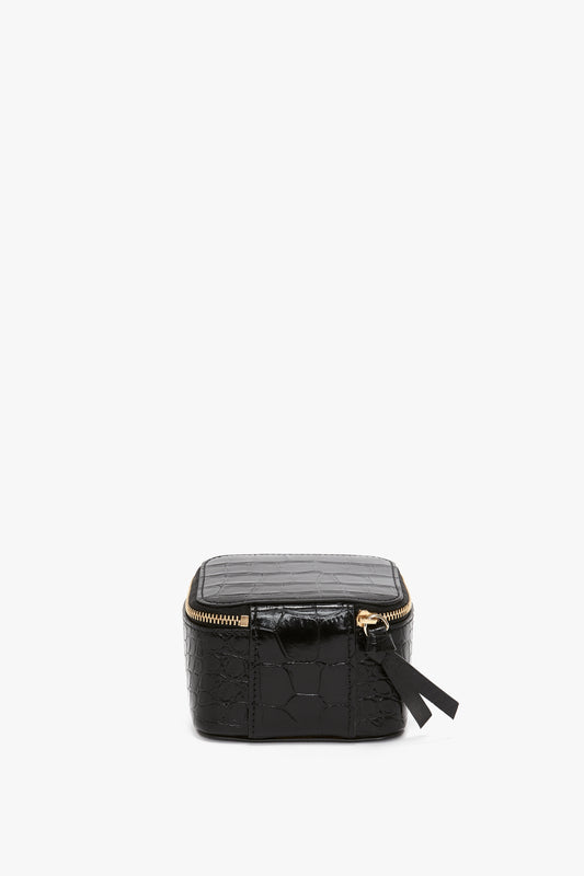 Jewellery Box In Black Croc-Effect Leather cosmetics bag with a gold zipper and a small bow detail, isolated on a white background by Victoria Beckham.