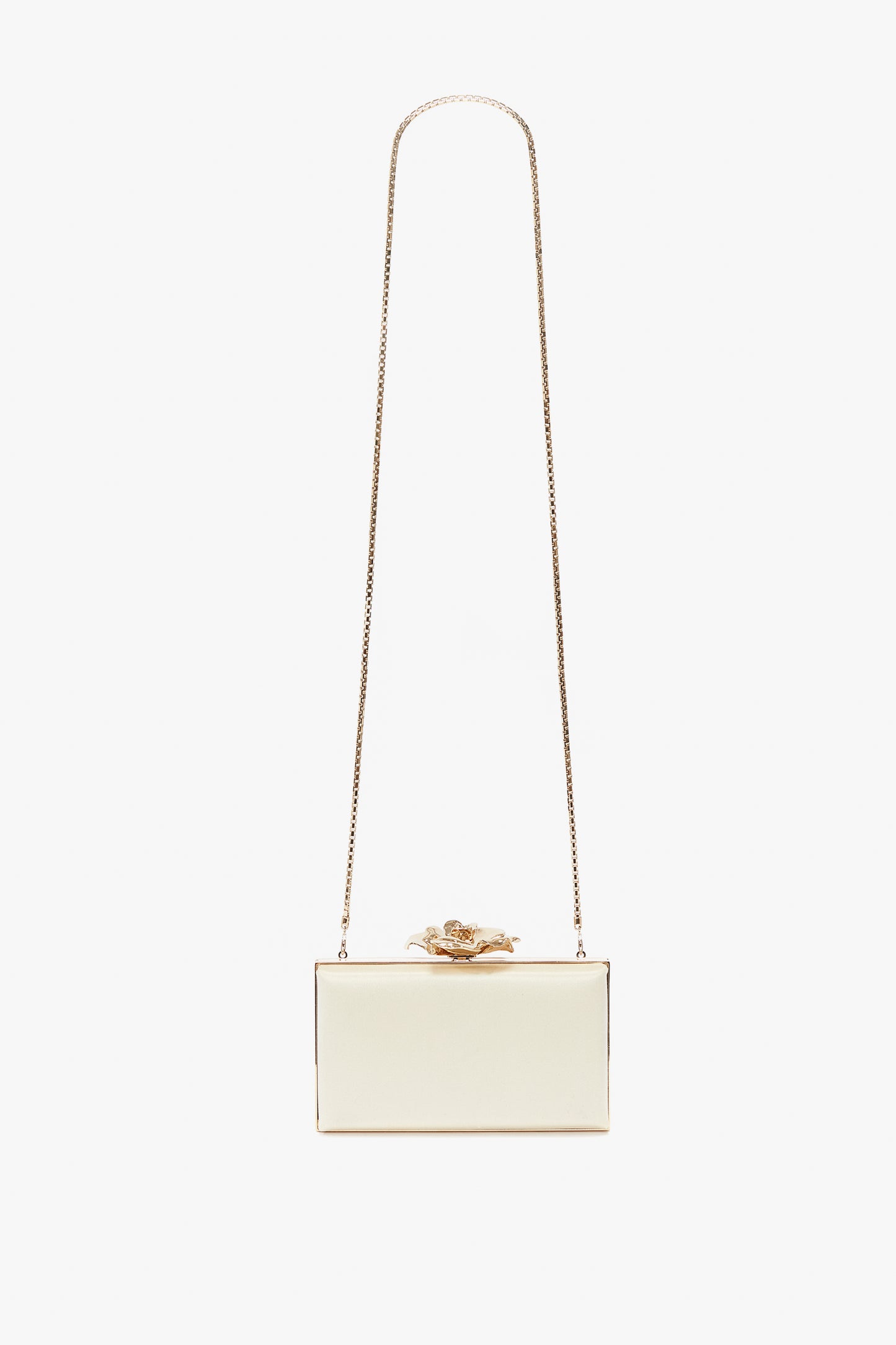 A small rectangular white Frame Flower Minaudiere Bag in Chamomile with a gold chain strap and a decorative gold flower on top, perfect for accessorizing like Victoria Beckham.