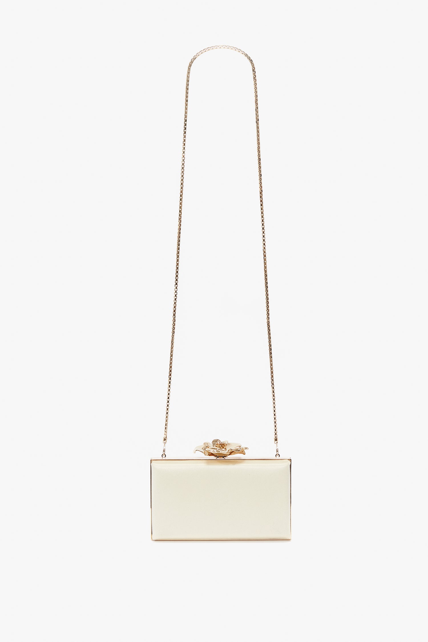 A small rectangular white Frame Flower Minaudiere Bag in Chamomile with a gold chain strap and a decorative gold flower on top, perfect for accessorizing like Victoria Beckham.