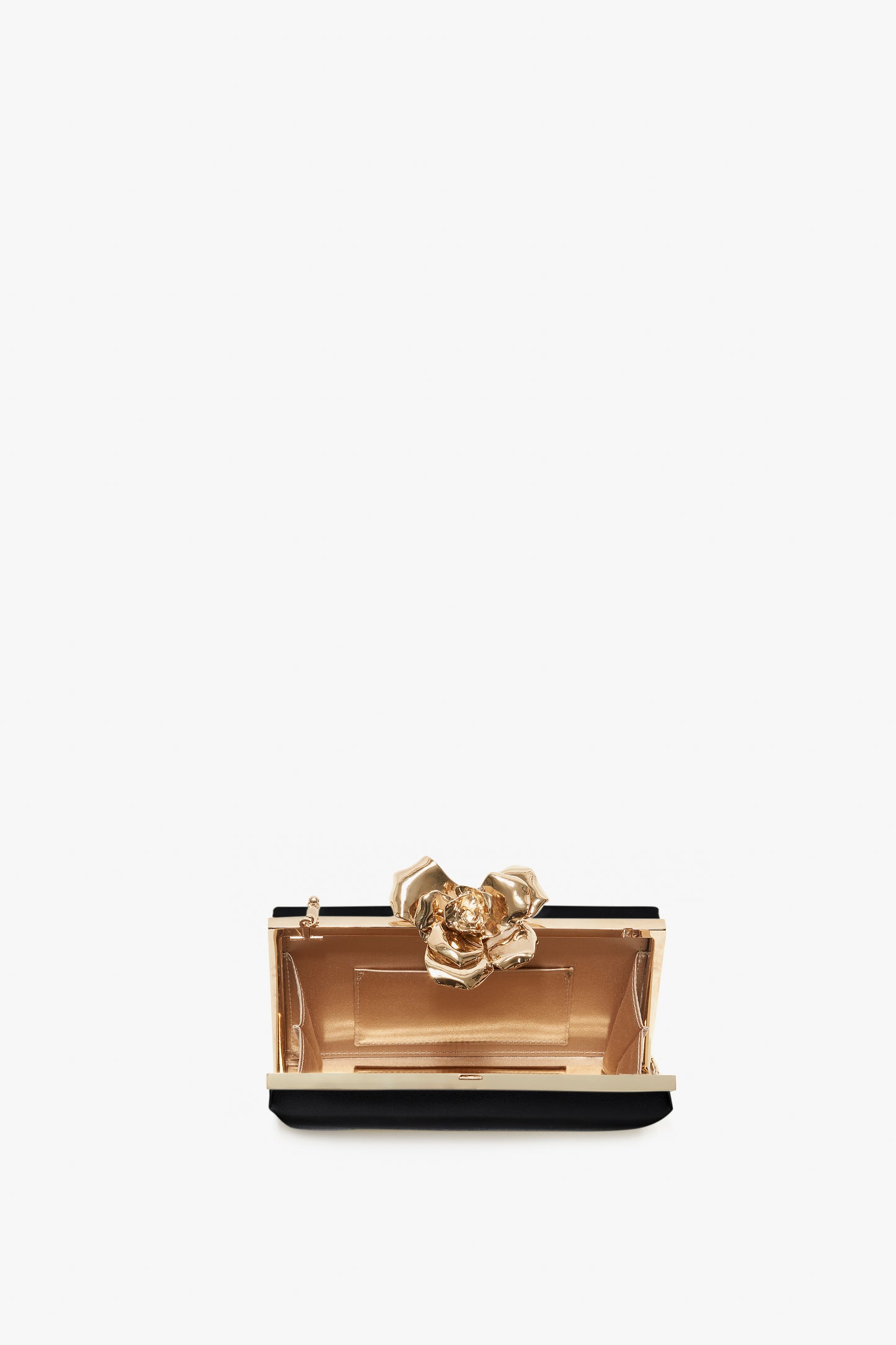A small, elegant Victoria Beckham black Frame Flower Minaudiere clutch purse with a prominent gold floral clasp and a detachable shoulder strap, displayed against a white background.