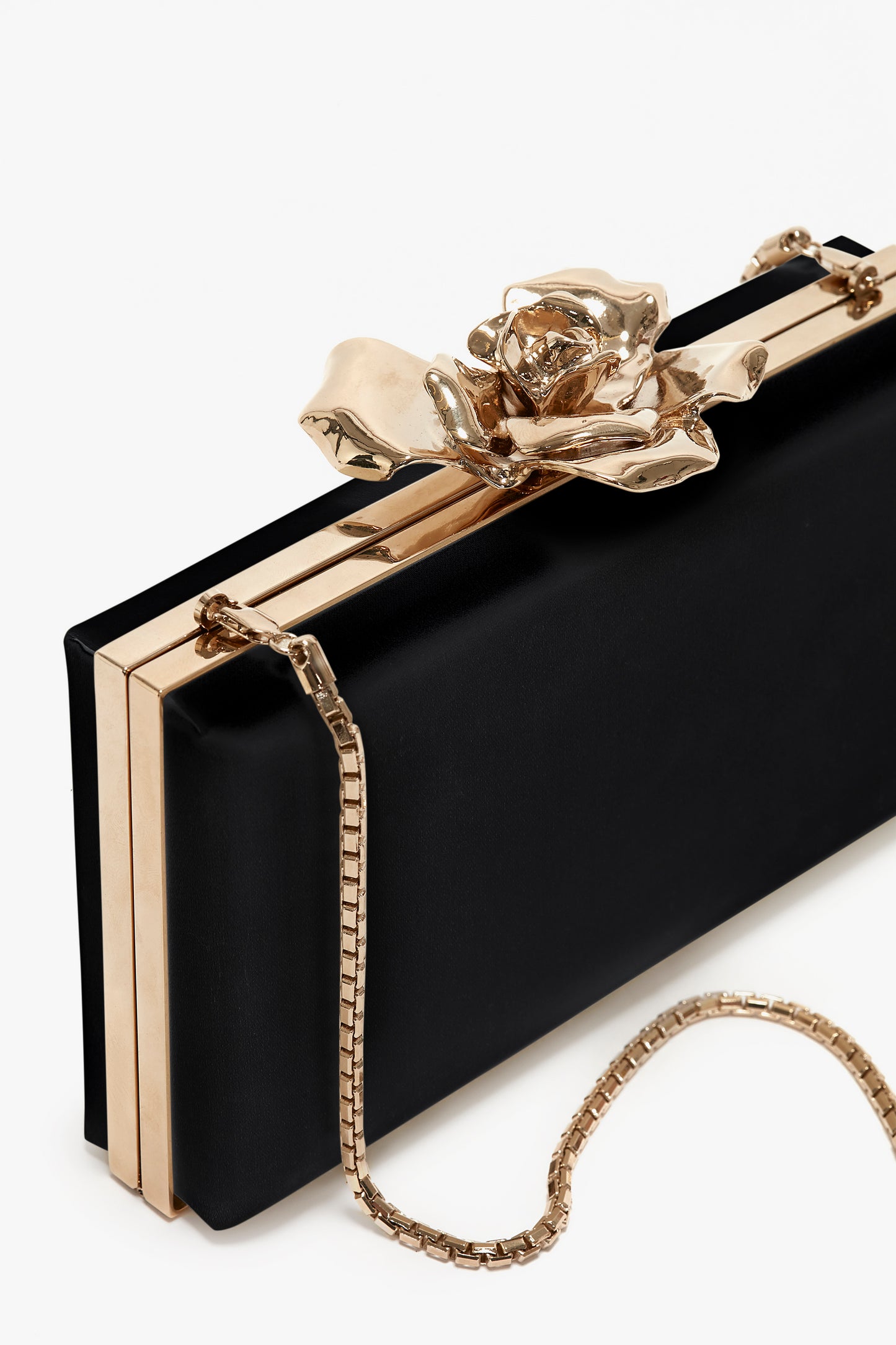 Frame Flower Minaudiere in Black by Victoria Beckham with a golden floral clasp and a detachable shoulder strap on a white background.