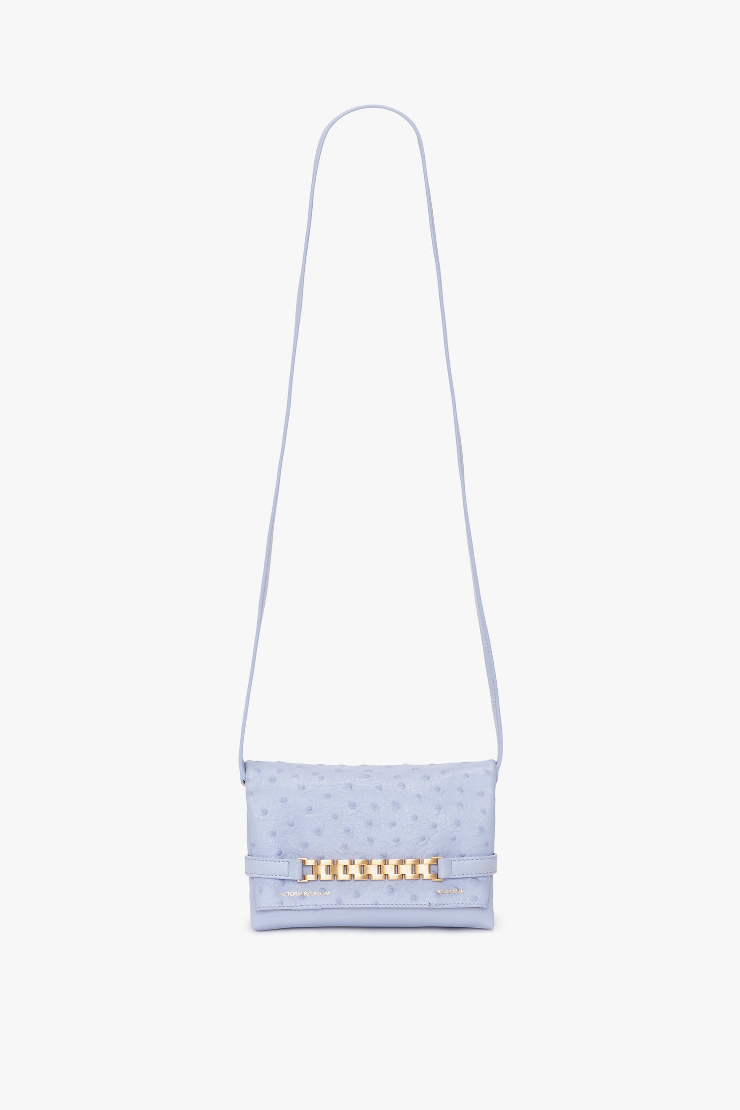 A light blue textured Mini Chain Pouch With Long Strap In Frost Ostrich-Effect Leather by Victoria Beckham, featuring a long strap and a gold-tone decorative clasp on the front.