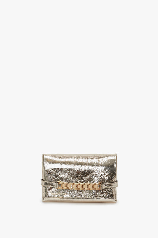 A metallic silver crossbody bag with a decorative golden clasp, displayed against a white background.