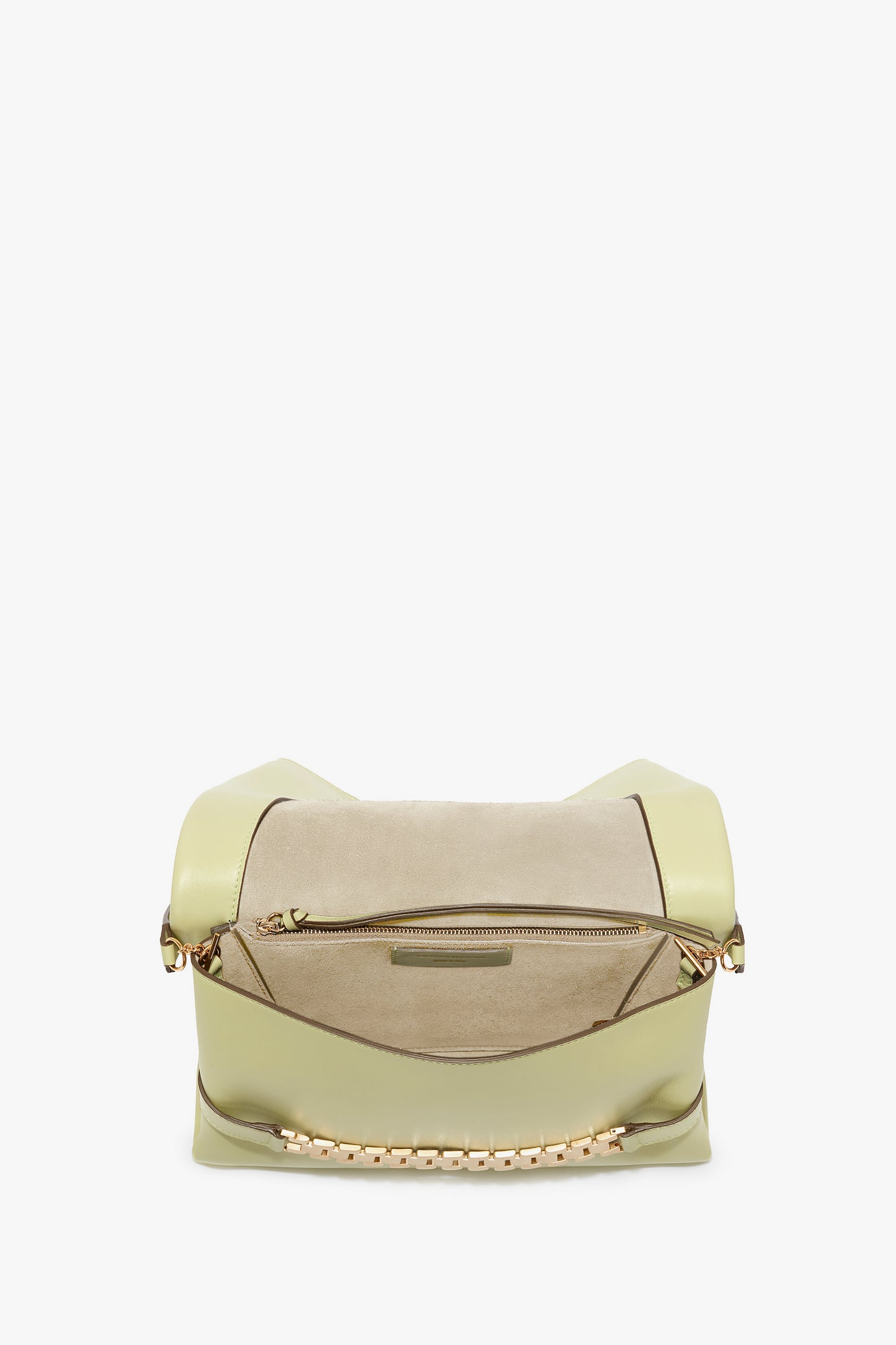 A beige and light green leather handbag in an avocado shade featuring a zipper pocket and gold chain accents on the handles, reminiscent of Victoria's vintage watch straps, viewed from the top. The Chain Pouch Bag With Strap In Avocado Leather by Victoria Beckham.