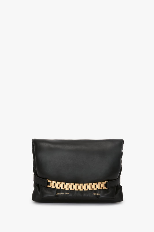 Puffy Chain Pouch With Strap In Black Leather by Victoria Beckham with a prominent gold chain detail across the front, displayed against a white background.