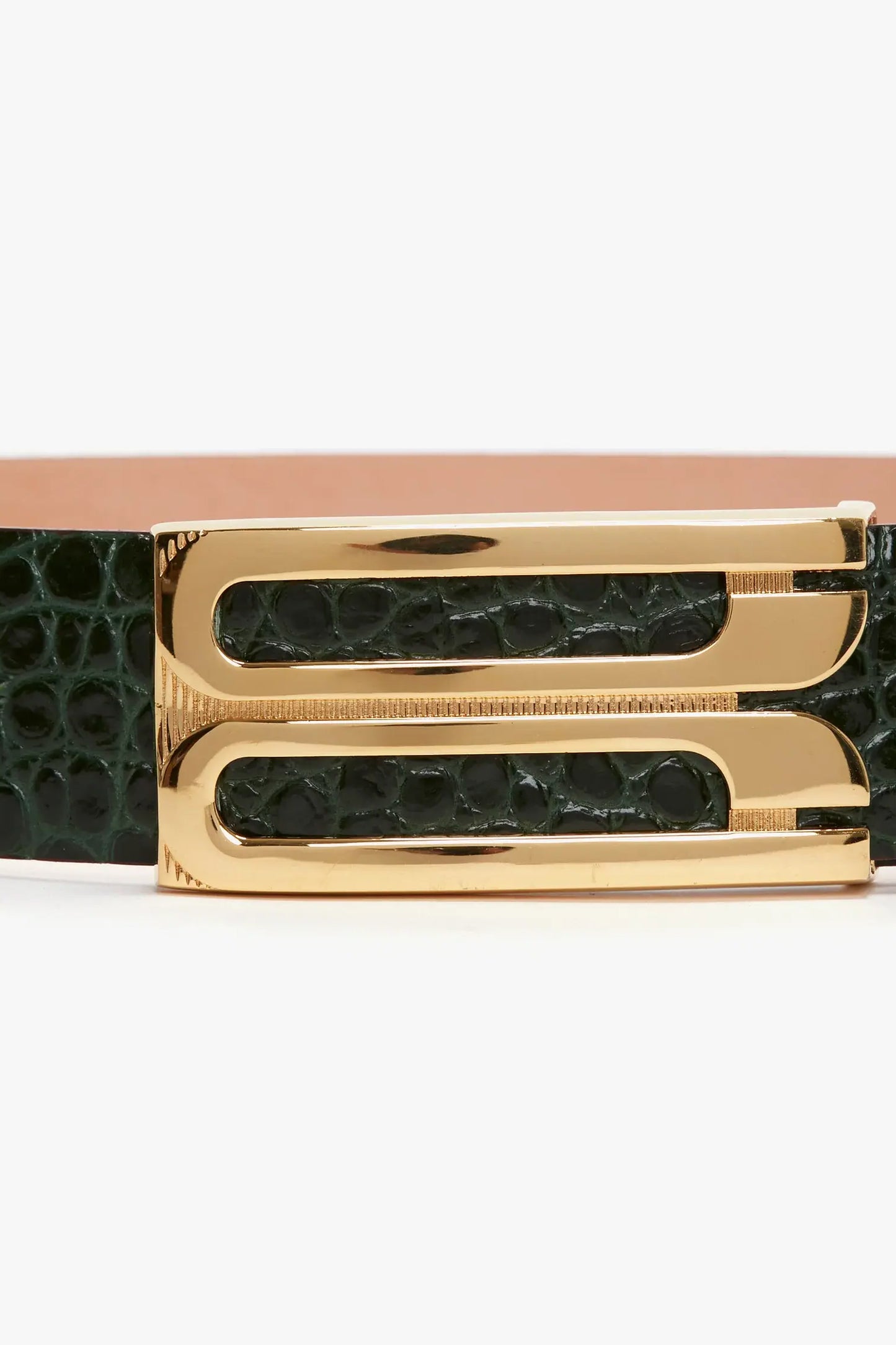 Close-up of a green leather belt featuring a gold-tone rectangular frame buckle with two parallel openings and a contemporary croc-effect finish.
Product: Jumbo Frame Belt In Dark Forest Croc-Effect Leather by Victoria Beckham