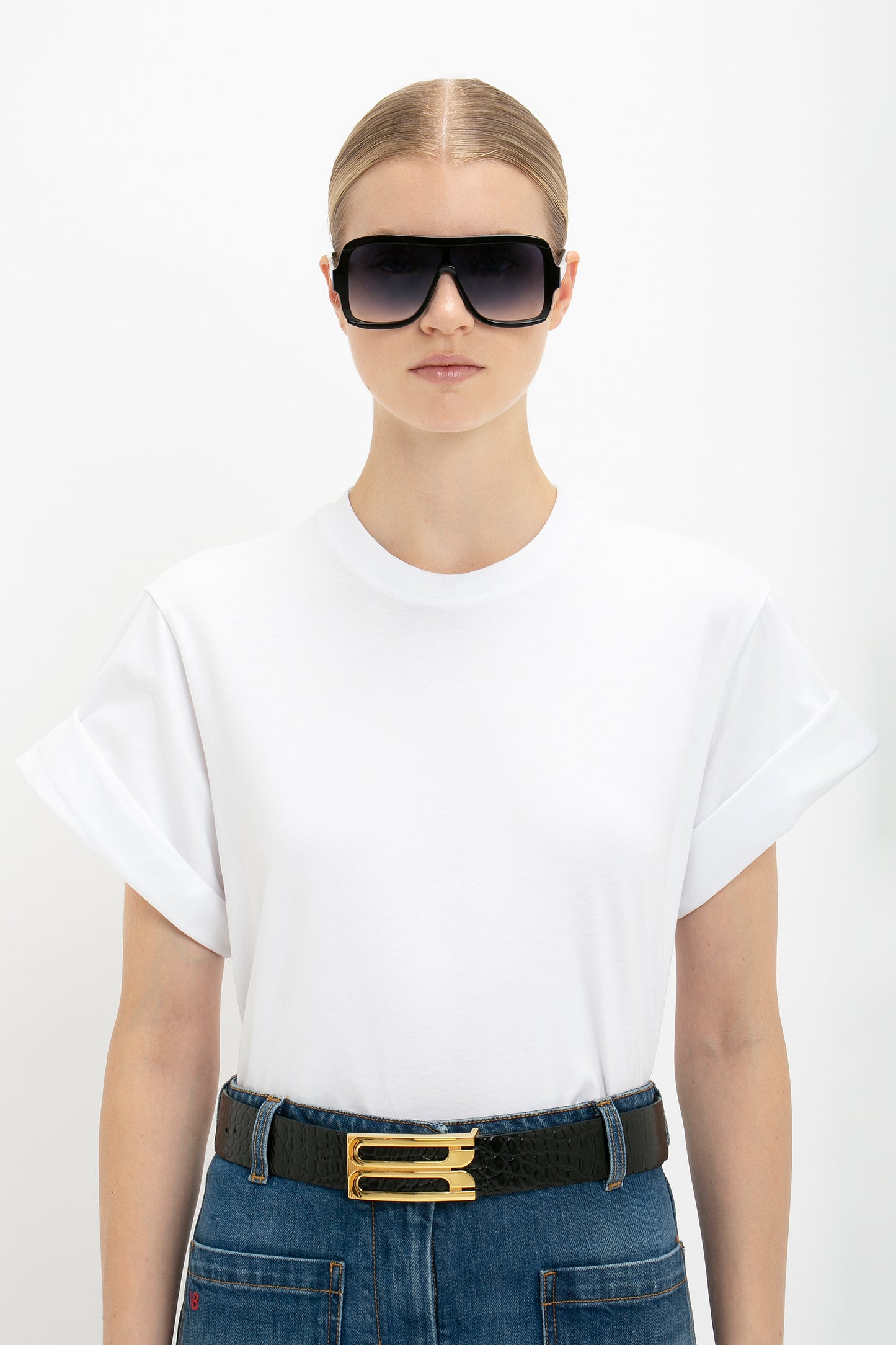 A woman wearing sunglasses and a Victoria Beckham Asymmetric Relaxed Fit T-shirt in White.