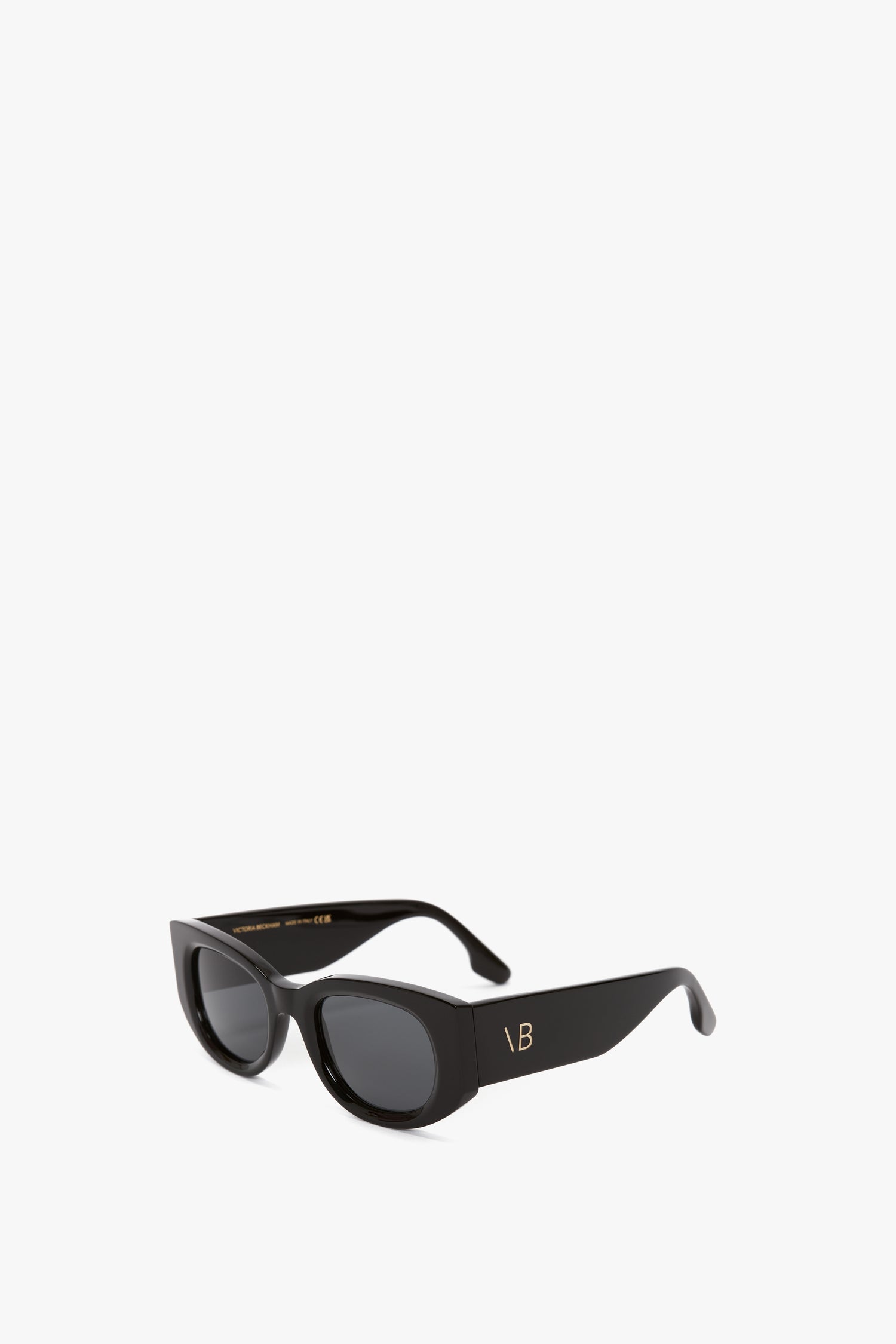 Black rectangular Monogram Detail Sunglasses In Black by Victoria Beckham with thick frames and dark lenses. The inside of the frame arm has gold text, giving these vintage-inspired acetate sunglasses a luxurious touch.