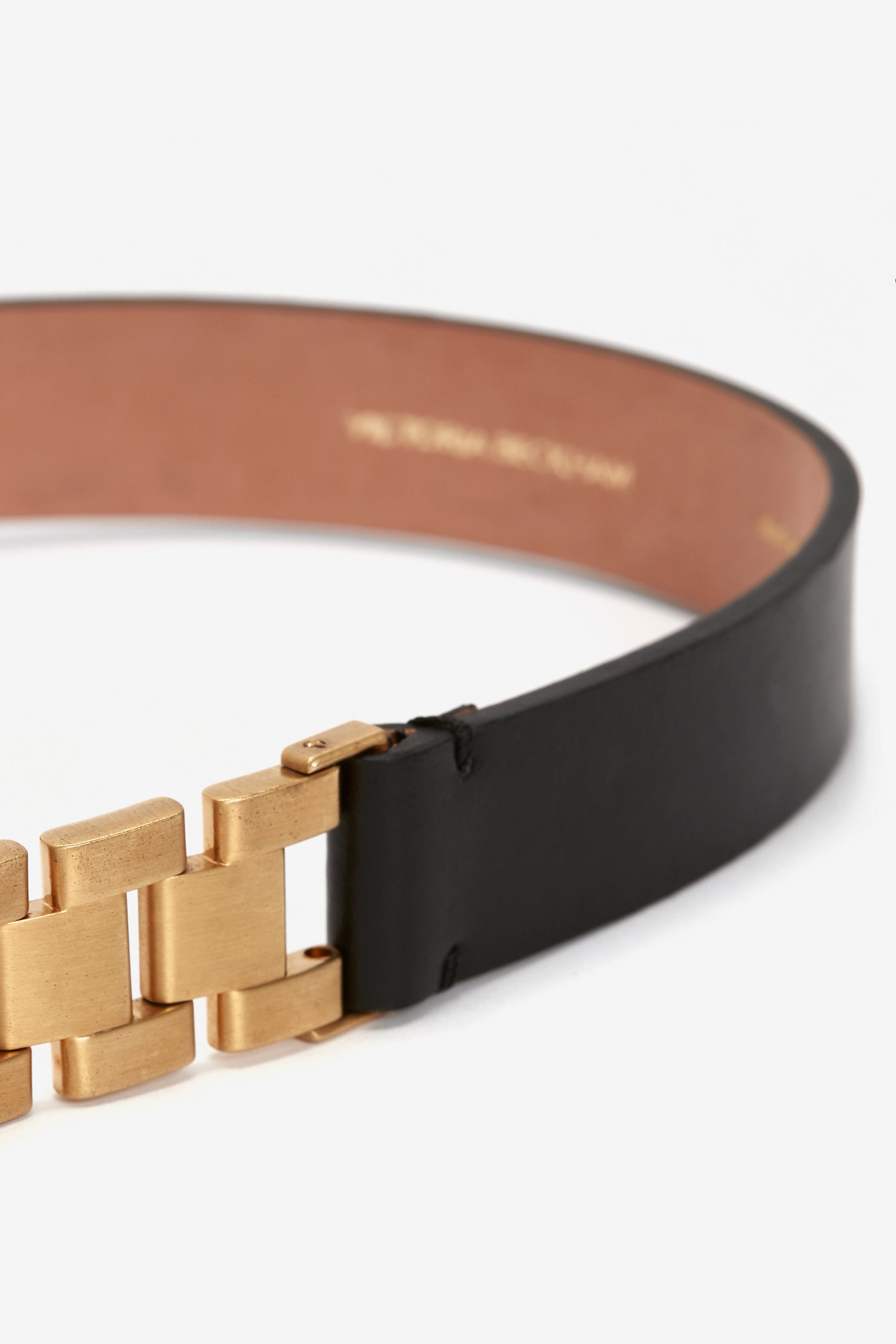 A close-up of the Watch Strap Detail Belt in Black by Victoria Beckham UK featuring a gold-tone metal buckle with geometrical links and a calf-leather finish.