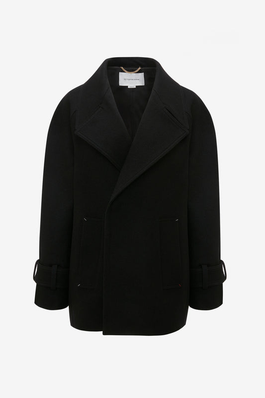 An Oversized Pea Coat In Black by Victoria Beckham, crafted from luxurious melton wool with masculine tailoring, features wide lapels, front pockets, and adjustable cuffs, displayed on a plain white background.